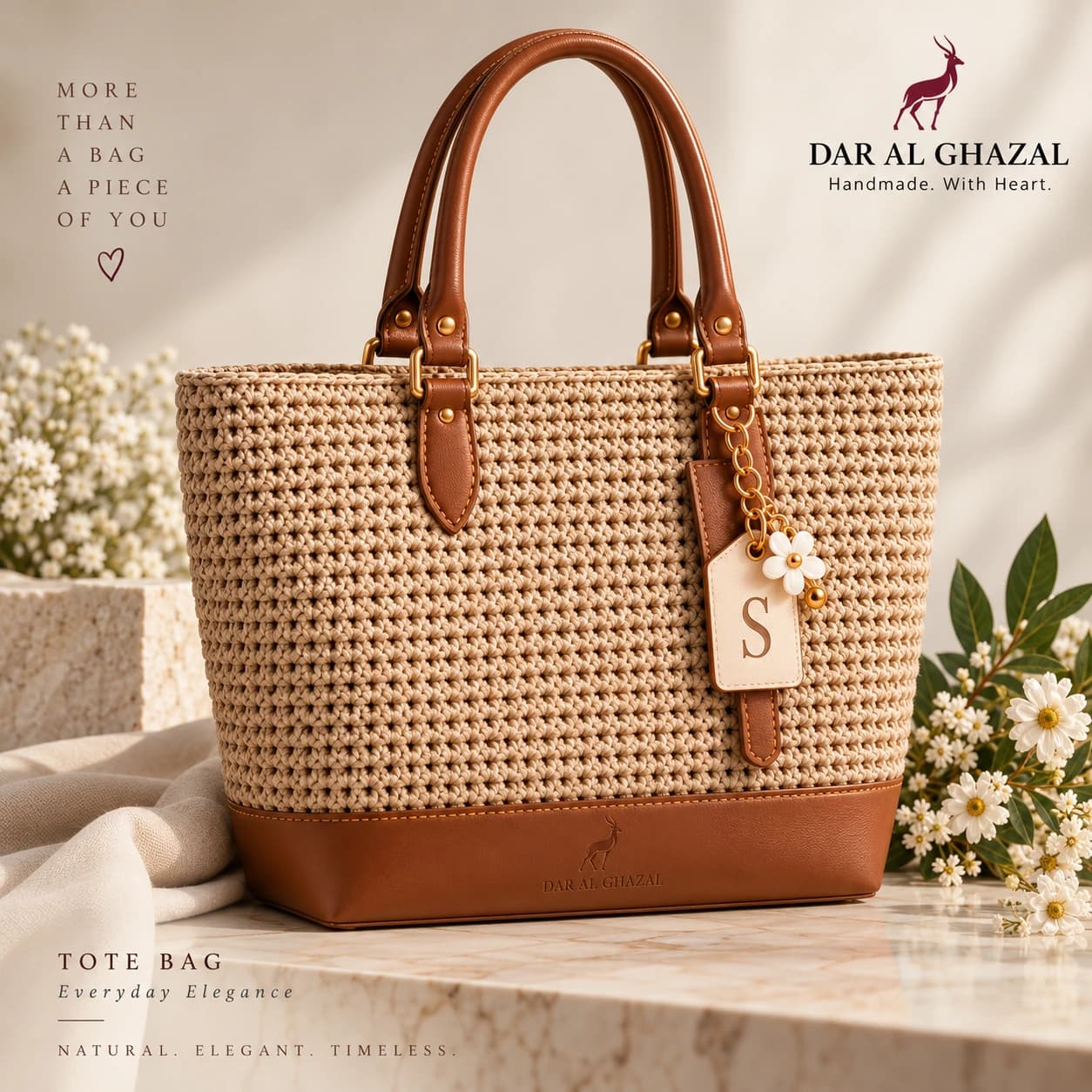 A natural raffia Dar Al Ghazal tote with a monogrammed leather tag and a daisy charm, styled with white blossom